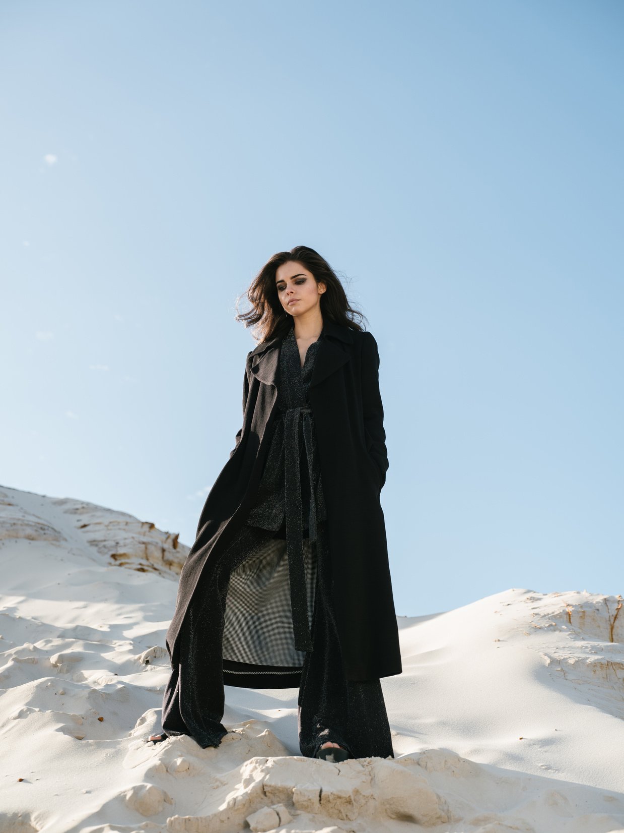 Fashionable woman standing on sandy slope